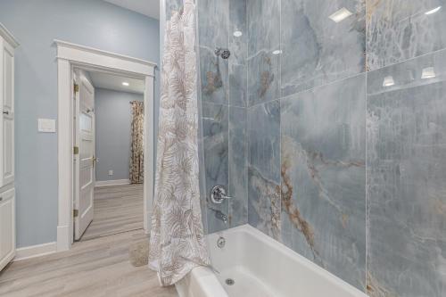 a bathroom with a shower with a tub at Beach Stunner in Galveston