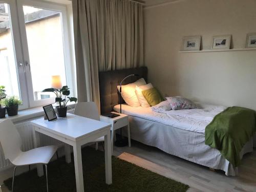 a bedroom with a bed and a table and a desk at Lilla Drottninggatan Apartment Hotel in Helsingborg