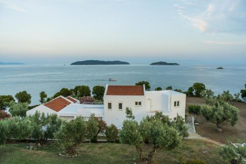 Cette maison blanche offre une vue sur l'océan. dans l'établissement Cape Blue Suites, à Achladies