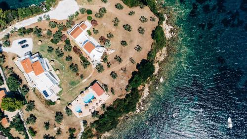 an aerial view of a house on an island in the water at Cape Blue Suites in Achladies