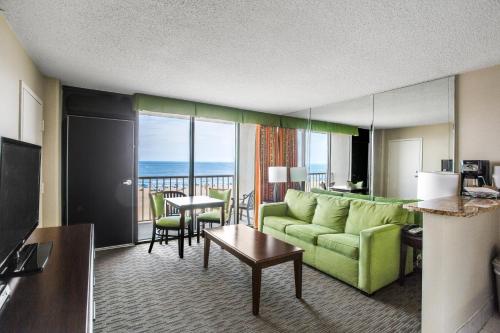 una sala de estar con sofá y una habitación con vistas. en Beach Quarters Resort en Virginia Beach