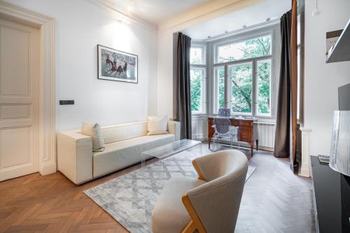 a living room with a couch and a window at Elegant Paris Ave apartment with a Terrace in Prague
