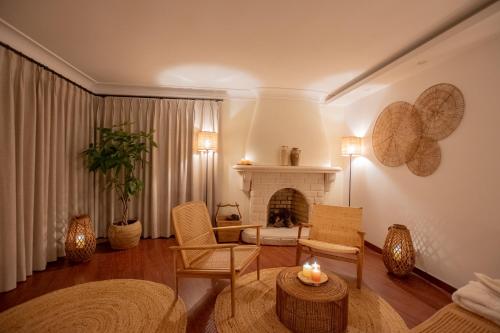 a living room with a fireplace and a table and chairs at Villa Pietra Estoril Eco Guesthouse in Estoril