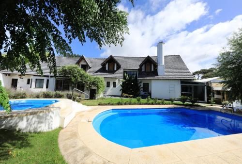 uma casa com piscina em frente a uma casa em Ars Amici Hotel em Punta del Este
