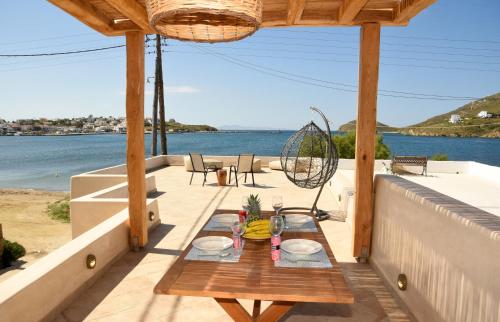einen Tisch auf einem Balkon mit Blick auf das Wasser in der Unterkunft Sea Senses Andros - Upper Retreat in Gavrio