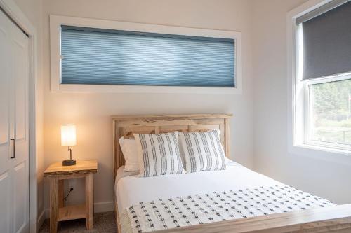 a bedroom with a white bed and a window at Mountain Dreams - Revelstoke Home Near RMR in Revelstoke