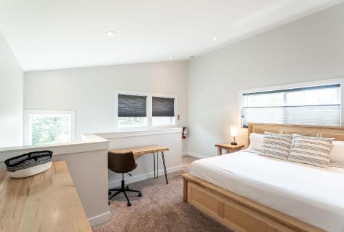 a white bedroom with a bed and a desk at Mountain Dreams - Revelstoke Home Near RMR in Revelstoke