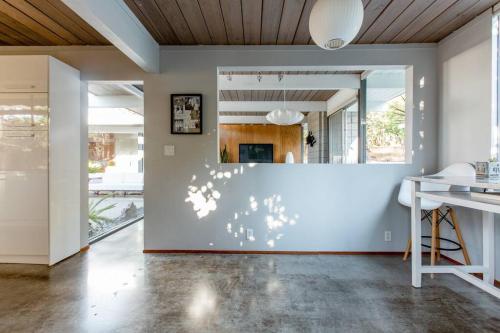 a living room with a white wall and a table at Eichler Mid Century Modern Designer Pool/Jacuzzi in Thousand Oaks