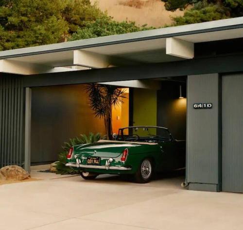 a green car is parked in a garage at Eichler Mid Century Modern Designer Pool/Jacuzzi in Thousand Oaks