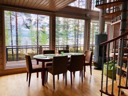 a dining room with a table and chairs and a large window at PielisLinna in Kolinkylä