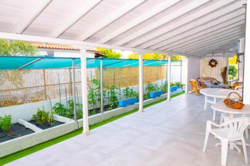 a patio with a white pergola and tables and chairs at Island house in Psakoudia
