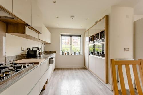 una cucina con armadi bianchi e piano cottura di Private Double bedroom a Thringstone