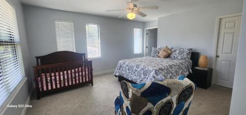 a bedroom with a bed and a crib and windows at Apartment in Ponte Vedra Beach in Ponte Vedra Beach