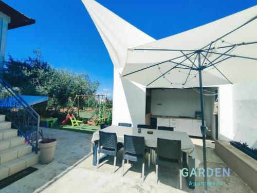 a white table and chairs under a white umbrella at Garden in Sutomišćica