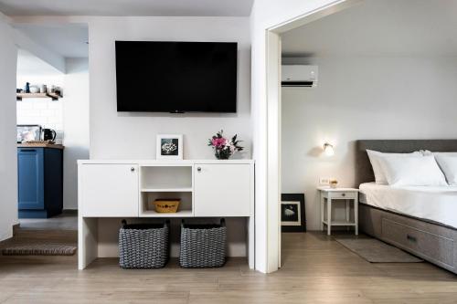 a bedroom with a white dresser with a tv on the wall at Charming Seaside House in Pag