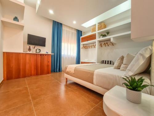 a hotel room with a bed and a tv at Don Antonio Rooms in Agropoli