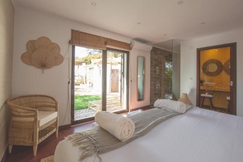 a bedroom with a large bed and a large window at Villa Pietra Estoril Eco Guesthouse in Estoril