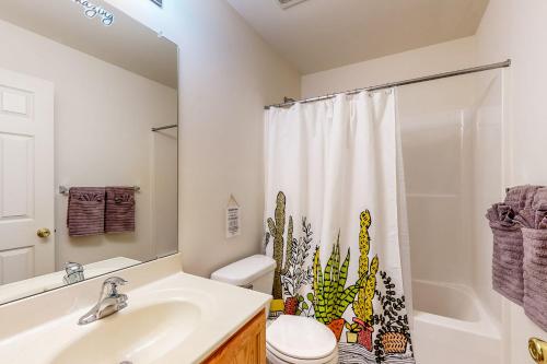 a bathroom with a sink and a toilet and a shower at The Garrison Getaway in Fruitland