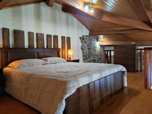 a bedroom with a large bed in a room with wooden ceilings at Recanto da Encosta - T2 in Bragança