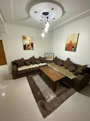ein Wohnzimmer mit einem Sofa und einem Tisch in der Unterkunft Pour Les FAMILLES Super et magnifique Appartement in Safi