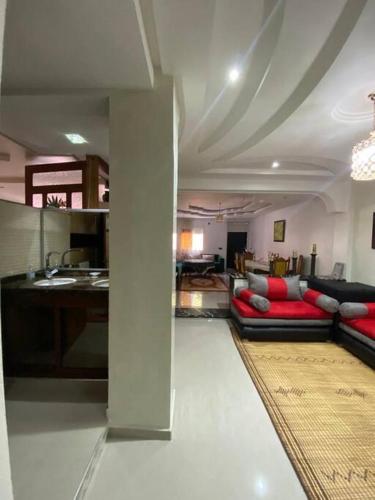ein Wohnzimmer mit einem Sofa und einer Küche in der Unterkunft Pour Les FAMILLES Super et magnifique Appartement in Safi