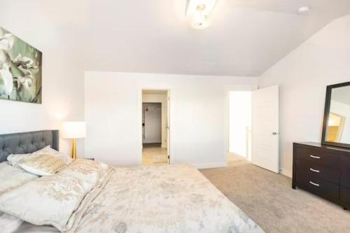 a white bedroom with a large bed and a dresser at NEW 4-bed 4-bath Stylish House with Mountain View and 2 garages in Lehi