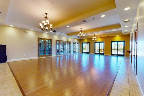 an empty ballroom with a wooden floor and chandeliers at Lake Havasu Lakehouse in Needles