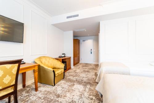 a hotel room with a desk and a bed at Hotel Piast in Opole