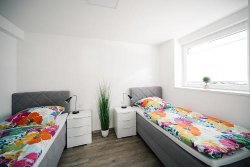 1 dormitorio con 2 camas y ventana en Ferienwohnung Lindbruchblick, en Niederkrüchten