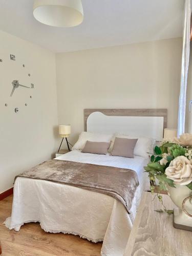 a bedroom with a large bed with a vase of flowers at Casa las Hiedras in Marín