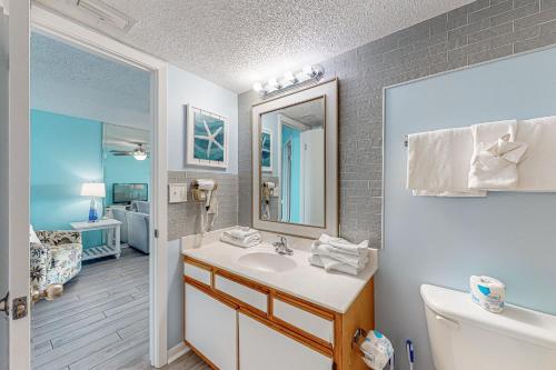 ein Badezimmer mit einem Waschbecken, einem WC und einem Spiegel in der Unterkunft Phoenix V 614 in Orange Beach