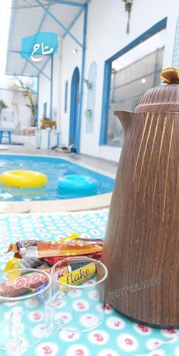 a table with a container of candy and a frisbee at شاليهات ليله الدرب in Qarār