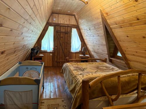 ein Schlafzimmer mit einem Bett in einer Holzhütte in der Unterkunft Old Dili in Dilidschan