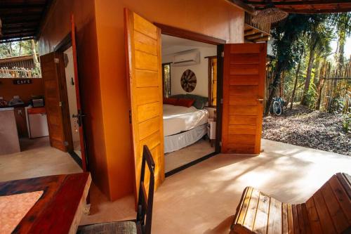 a bedroom with a bed and an open door at Casa aconchegante na Bahia para viver uma experiência de hospedagem pertinho da praia in Marau