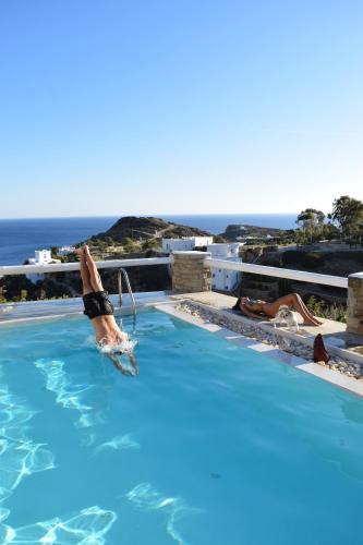 una persona in una piscina con l'oceano sullo sfondo di Villa Giulia, seaview villa a Ios Chora