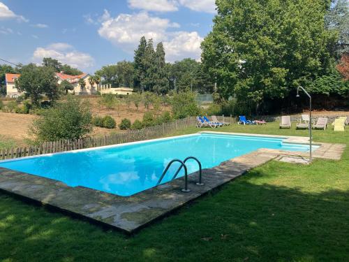a swimming pool in the yard of a house at Casa da Barragem in Venda Nova