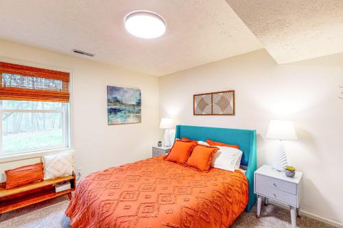 Un dormitorio con una cama grande con almohadas naranjas. en Bloomington Beauty, en Bloomington