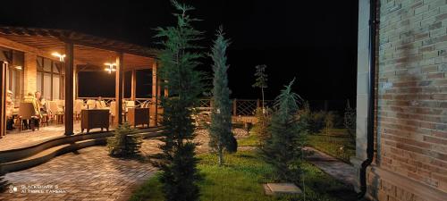 a patio at night with christmas trees in the yard at River View Villas in Qusar