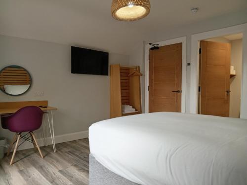 a bedroom with a bed and a desk and a television at No.5 in Derry Londonderry