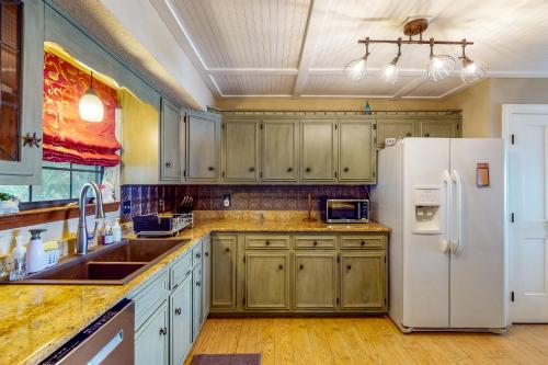 a kitchen with wooden cabinets and a white refrigerator at Get a Wave From it All in Pensacola
