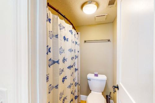 a bathroom with a toilet and a shower curtain at Get a Wave From it All in Pensacola