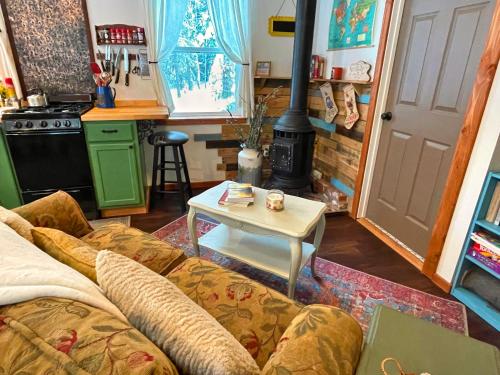 a living room with a couch and a table at Kataluma Inn, Sandpoint, Idaho - Entire Cozy Cabin, Pet Friendly in Sandpoint