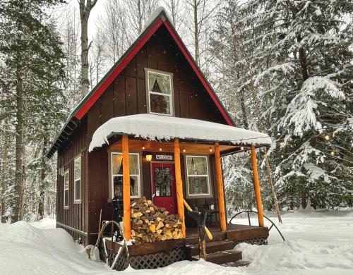 a small cabin with a red roof in the snow at Kataluma Inn, Sandpoint, Idaho - Entire Cozy Cabin, Pet Friendly in Sandpoint