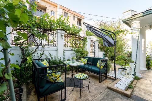 a patio with a table and chairs and a fence at French House in Belgrade