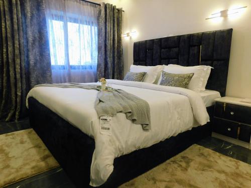 a large bedroom with a large bed with white sheets at Résidence Bouba Bamako in Bamako