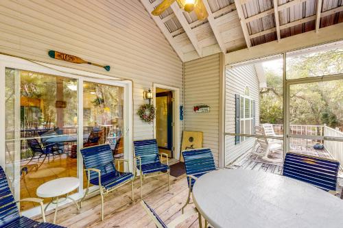 a room with a table and chairs on a porch at River Watcher in Bell