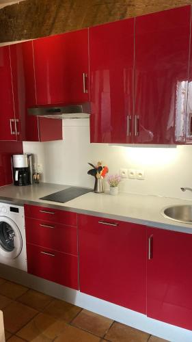a kitchen with red cabinets and a sink at Appartement Paris rue Montorgueil in Paris