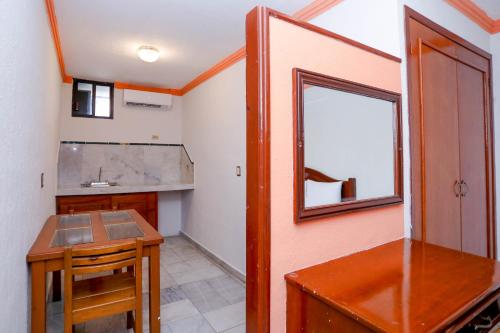 una pequeña cocina con mesa y espejo en Hotel Avenida Cancun, en Cancún