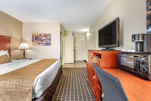 a hotel room with a bed and a flat screen tv at Best Western Plus Bridgeport Inn in Bridgeport
