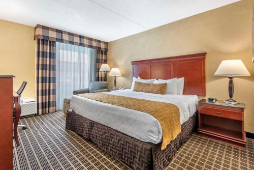 a hotel room with a large bed and a large window at Best Western Plus Bridgeport Inn in Bridgeport